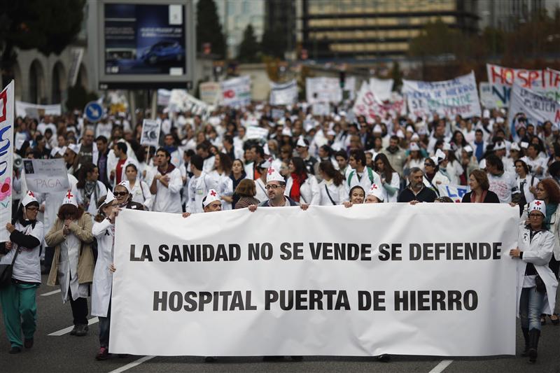 Demonstrators march behind a banner that reads Healthcare is not for sale, we have to defend it. Puerta de Hierro hospital during a protest in Madrid