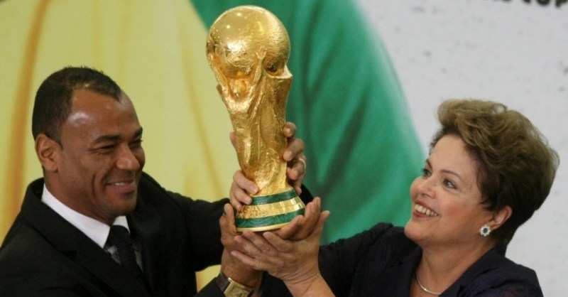 2jun2014---a-presidente-dilma-rousseff-ao-lado-do-o-ex-jogador-e-campeao-do-mundo-cafu-levanta-a-taca-da-copa-do-mundo-apos-recebe-la-do-presidente-da-fifa-joseph-blatter-durante-cerimonia-no-palacio-1401741709738_956x500